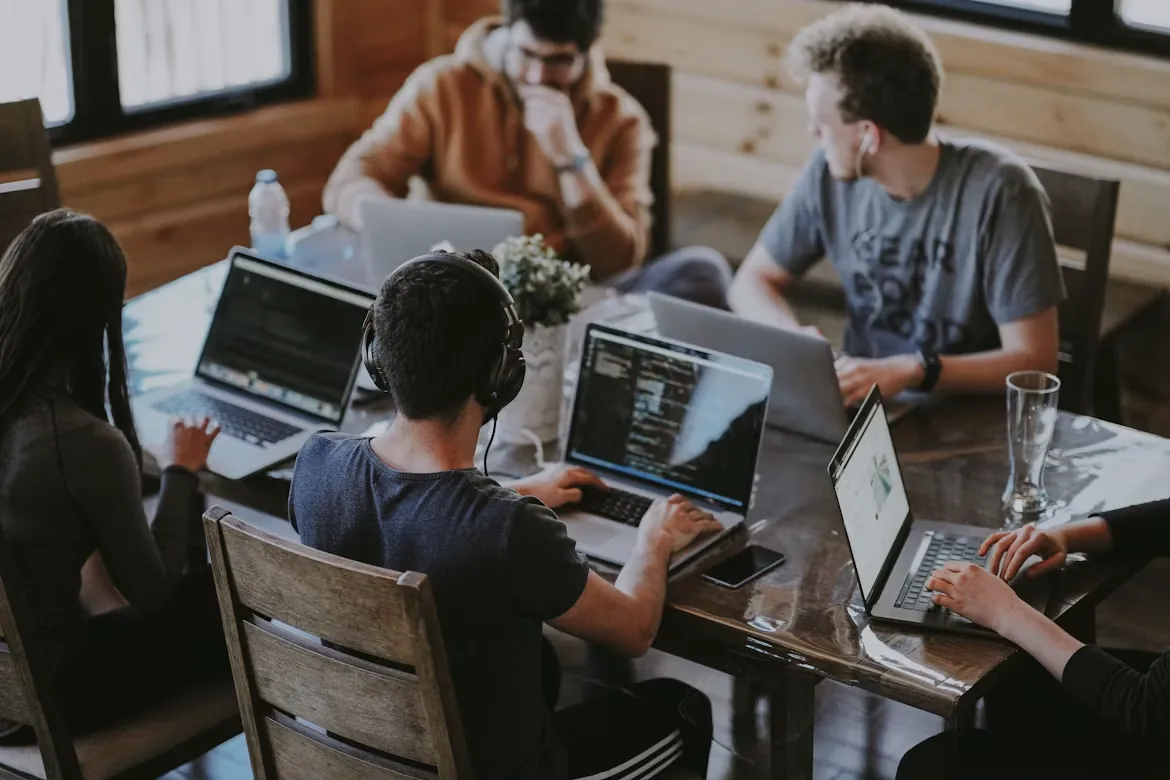 People working together on laptops around a shared table
